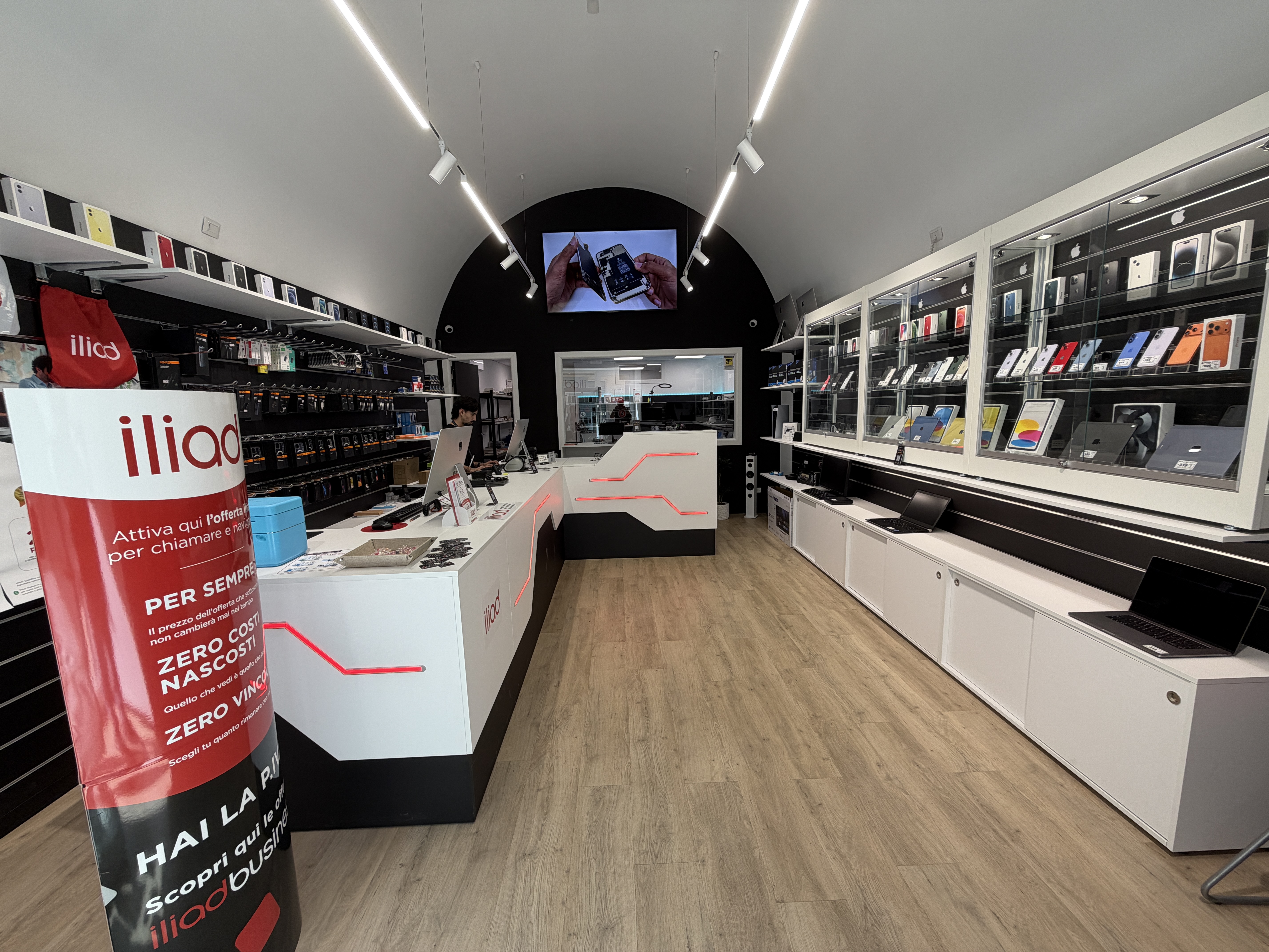 Interno del negozio PC SERVICE a Molfetta: banconi, vetrine con smartphone e area riparazioni